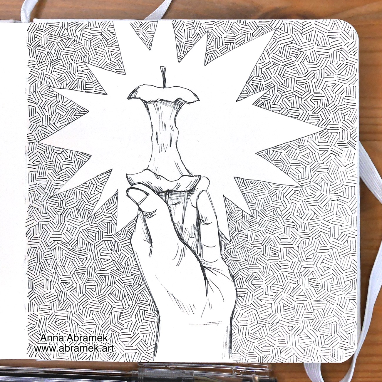 A pen drawing of a hand holing up an apple core as if it was a gem.